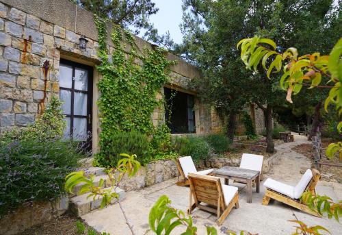 a patio with chairs and a table in front of a building at Blue Jay Valley in Jezzîne