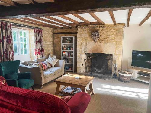 a living room with a couch and a fireplace at Bakers Retreat in Cottesmore