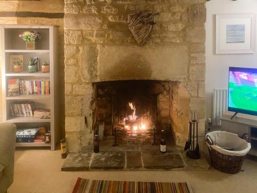 a fireplace in a living room with a fire in it at Bakers Retreat in Cottesmore