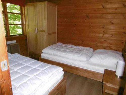 2 camas en una habitación con paredes de madera en Twistesee Ferienhaus 110, en Bad Arolsen