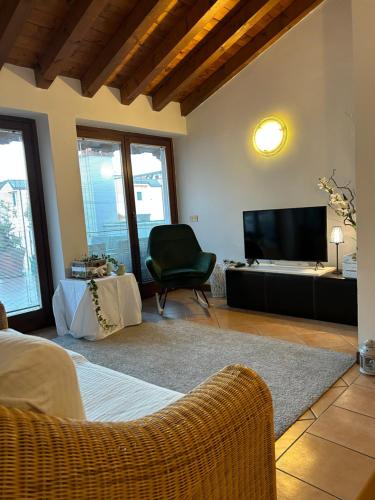 a living room with a television and a chair at Gabriel’s Home in Salò