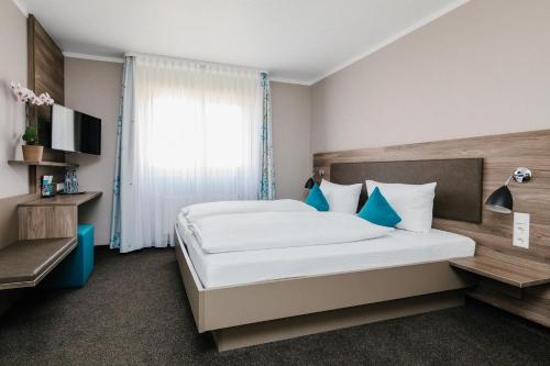 pokój hotelowy z dużym łóżkiem i oknem w obiekcie Tagungszentrum Blaubeuren w mieście Blaubeuren