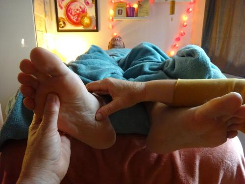 a person laying on a bed with their feet up at A L'inattendue in Bertrix