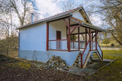 a small house with a porch and a staircase at Le chalet du bout du monde, en bord de rivière ! in Grez-sur-Loing