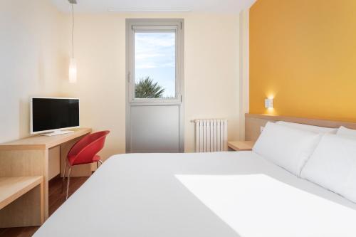 Dormitorio con cama, escritorio y TV en Hotel 280 Zaragoza, en Calatorao