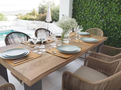 ein Holztisch mit Tellern und Weingläsern darauf in der Unterkunft Can Lovers in Sant Jordi