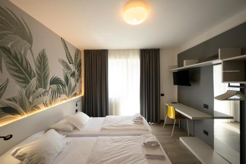 ナーゴ・トルボレにあるPark Hotel Edenのベッドとデスクが備わるホテルルームです。