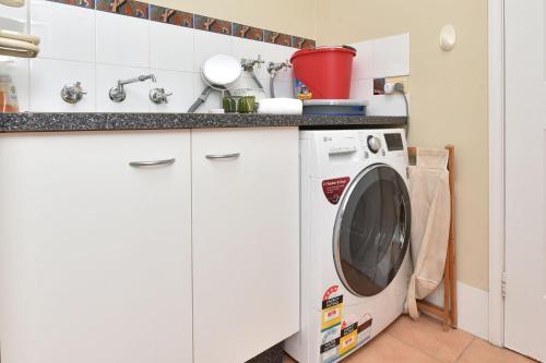 a kitchen with a washing machine and a sink at Silver Springs 4br Cottage in Rothbury