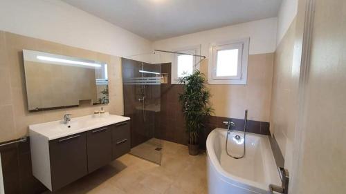 łazienka z umywalką, wanną i toaletą w obiekcie La maison de vacances de Campoussin w mieście Montfrin