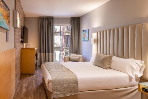 バルセロナにあるHotel Sansi Barcelonaのベッドと窓が備わるホテルルーム