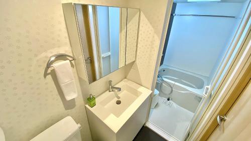 a bathroom with a sink and a mirror at One More Heart Fushimi Inari in Momoyama-chō
