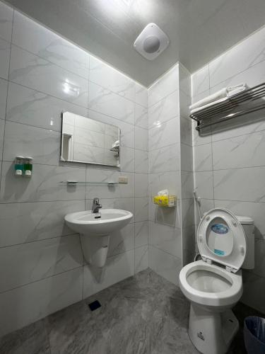 a white bathroom with a toilet and a sink at 上海民宿 in Chaozhou
