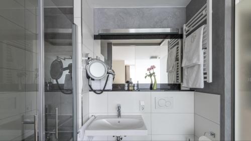 ein Bad mit einem Waschbecken und einem Spiegel in der Unterkunft Zeitlers Hotel in Marsberg