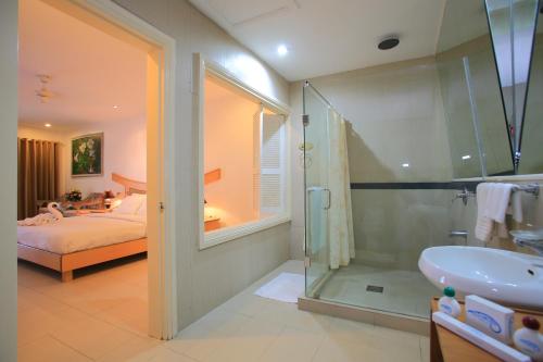 a bathroom with a bed and a shower and a sink at Wild Orchid Beach Resort in Olongapo