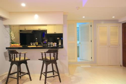 a kitchen with two bar stools and a counter at Wild Orchid Beach Resort in Olongapo