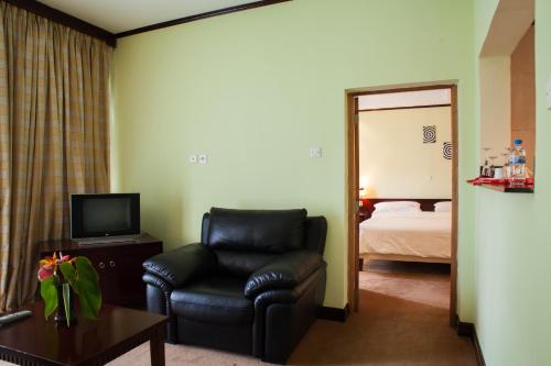 a living room with a chair and a television at Gorillas Lake Kivu Hotel in Gisenyi