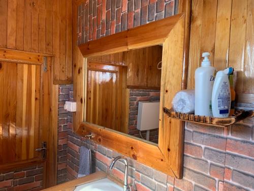 a kitchen with a sink and a mirror and a counter at THE WONDERLAND COTTAGES & Cafe in Nārkanda