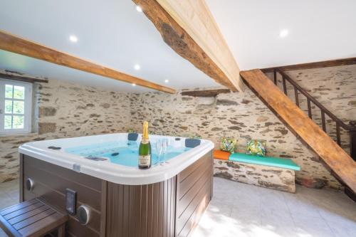 a bathroom with a hot tub in a attic at Newly renovated fort with panoramic landscape view jacuzzi & billiard in Leynhac