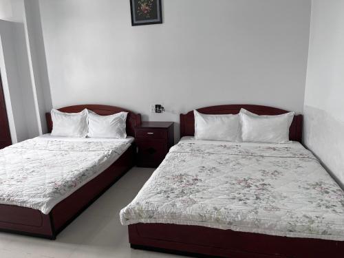 dos camas sentadas una al lado de la otra en un dormitorio en Sea Stars Hotel, en Rạch Giá