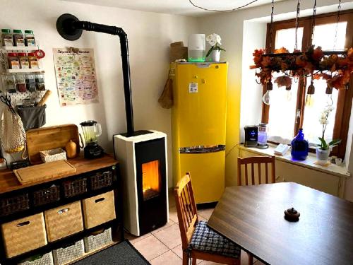 una cucina con tavolo e frigorifero giallo di in lak'ech - rooms a Chironico