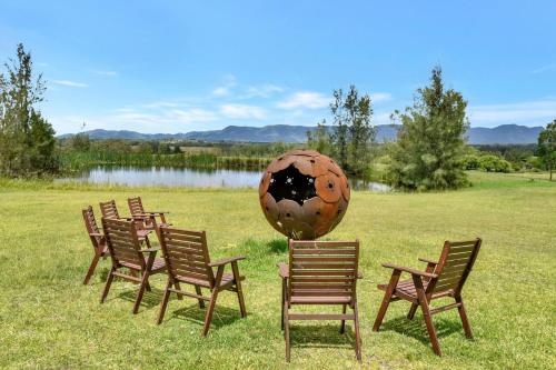 a group of chairs in a field with a large sculpture at Silver Springs 6br Luxury Homestead in Rothbury
