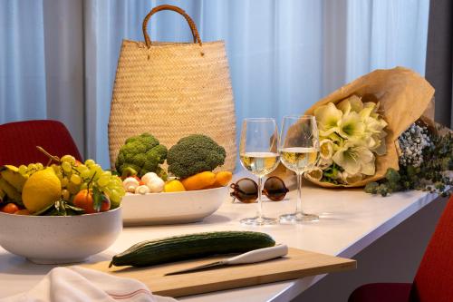 a table with two glasses of wine and fruits and vegetables at L-Avenue in Brussels