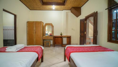 a room with two beds and a bathroom at Raka House Accommodation in Ubud