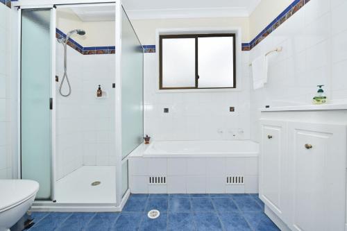a white bathroom with a shower and a sink at Silver Springs Estate in Rothbury