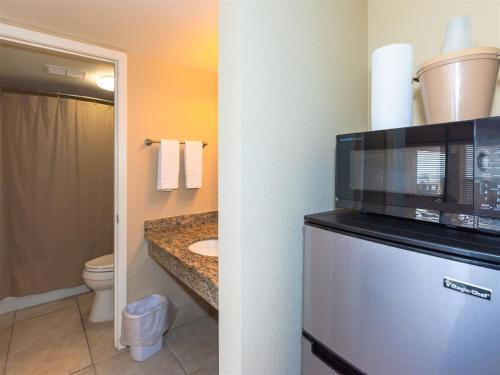 a bathroom with a microwave on top of a refrigerator at LR 114 - The Seahorse Room in Rockport