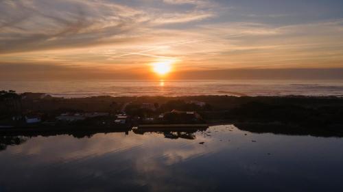 a sunset over the ocean with the sun setting at Sense of Ofir in Fão