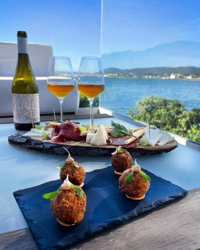 a table with two glasses of wine and some food at Sense of Ofir in Fão