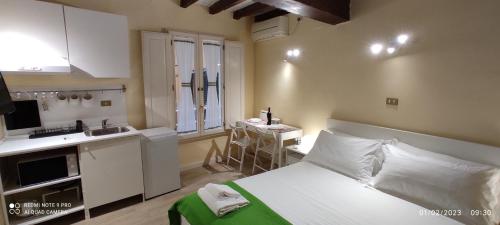 een kleine kamer met een bed en een keuken bij Appartamento Mughetto in Florence
