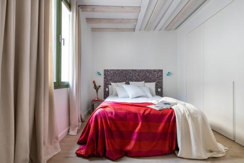 a bedroom with a bed with a red blanket at Calatrava - Darya Living in Madrid