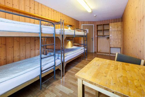 a room with two bunk beds and a table at Engelberg Youth Hostel in Engelberg