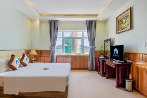a hotel room with a bed and a television at Sky Beach D20 Nha Trang in Nha Trang