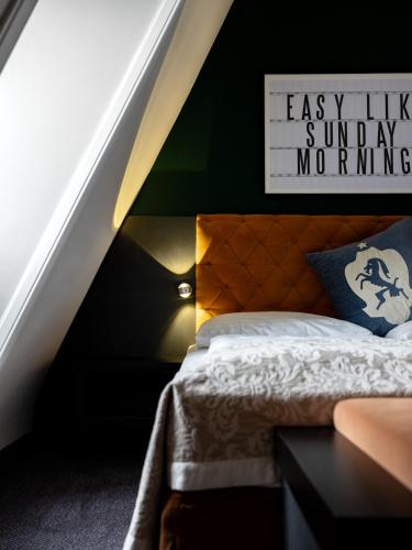 a bedroom with a bed and a sign on the wall at Hotel Villa Carlton - Adults Only in Salzburg