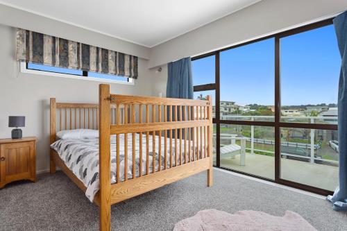 ein Schlafzimmer mit einem Etagenbett und einem großen Fenster in der Unterkunft Treasure on Tawai - Ohope Holiday Home in Ohope Beach