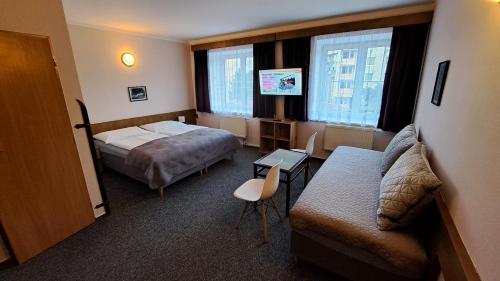 um quarto de hotel com uma cama e um sofá em Pension PAVIR em Židlochovice