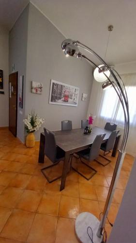 a dining room with a table and chairs and a lamp at Villa Vittorio in Infernetto