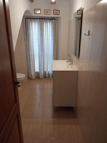 a bathroom with a sink and a mirror and a toilet at Cal Tort in Cornudella