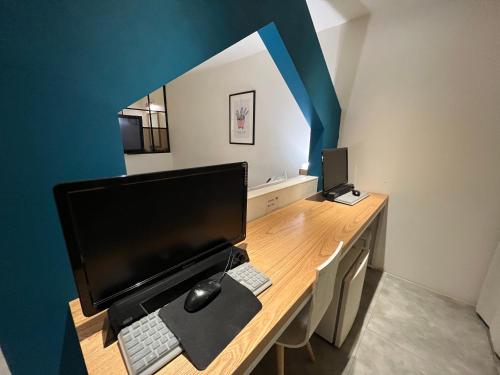 a desk with a computer monitor and a keyboard at Hotel Yaja Hwajeong Station in Goyang