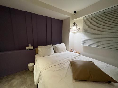 a bedroom with a large bed with white sheets at Hotel Yaja Hwajeong Station in Goyang