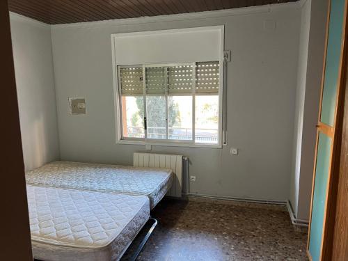 1 Schlafzimmer mit 2 Betten und einem Fenster in der Unterkunft House of sabadell in Sabadell
