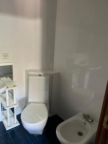 a bathroom with a white toilet and a sink at House of sabadell in Sabadell