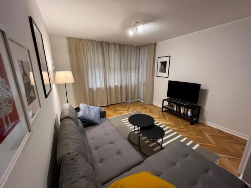 ein Wohnzimmer mit einem Sofa und einem TV in der Unterkunft OhMyHome - Platynowa in Warschau