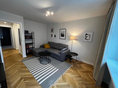 ein Wohnzimmer mit einem Sofa und einem Teppich in der Unterkunft OhMyHome - Platynowa in Warschau