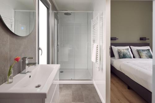 La salle de bains est pourvue d'un lit, d'une baignoire et d'un lavabo. dans l'établissement Hofparken De Bergvennen, à Lattrop