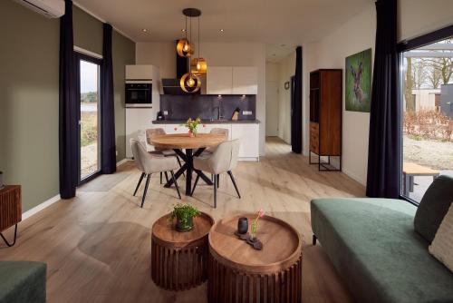 a living room and kitchen with a table and chairs at Hofparken De Bergvennen in Lattrop