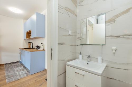 een witte badkamer met een wastafel en een spiegel bij LANA Sea View Apartment in Kotor
