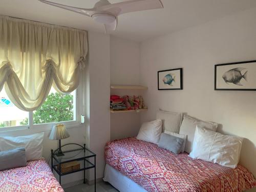 マルベーリャにあるPenthouse Arenal Playaのベッドルーム1室(ベッド2台、窓付)